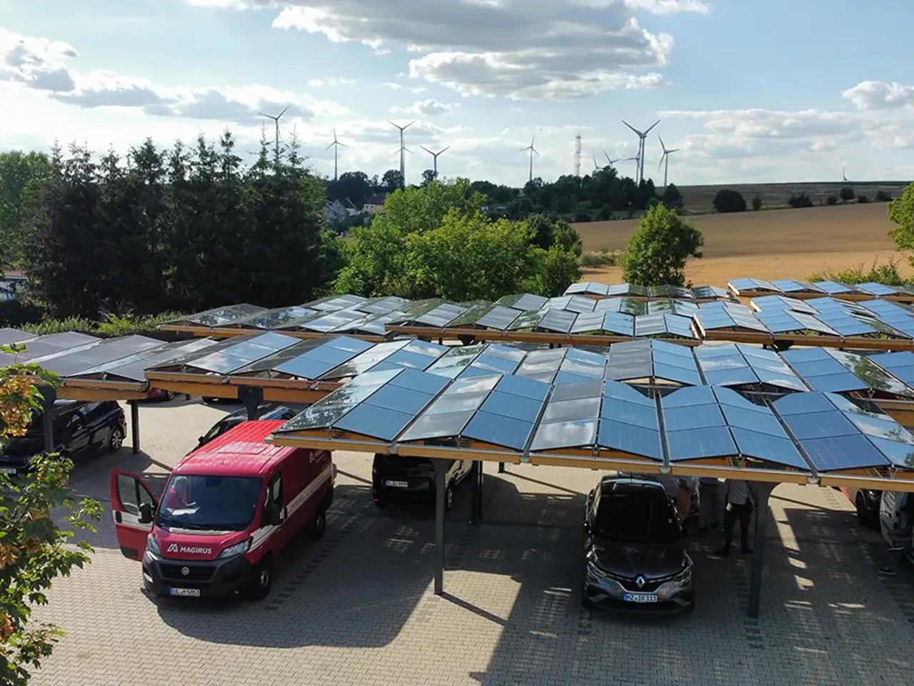 Eine Reihe von E-Autos, die an Ladesäulen unter Solarcarporte in Deutschland laden
